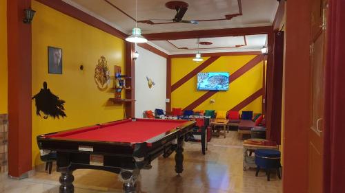 a pool table in a room with yellow walls at Hogwartz Hostel in Kasol