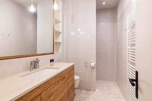 a bathroom with a sink and a toilet and a mirror at Kultur Gut Hasselburg in Altenkrempe