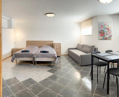 ein Schlafzimmer mit einem Bett, einem Sofa und einem Tisch in der Unterkunft Klinikų apartamentai in Kaunas