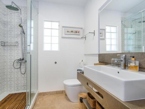 bagno bianco con lavandino e doccia di Casa Lloc Tranquil a Cala Figuera