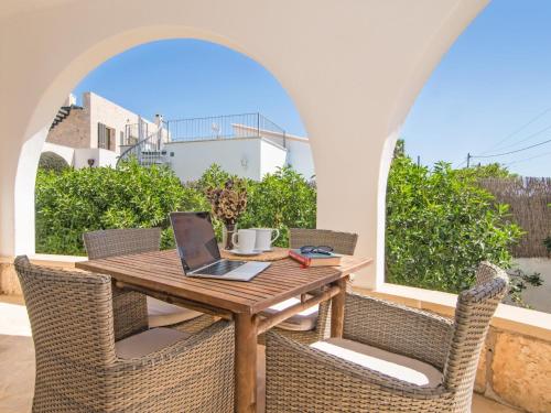 an outdoor table with chairs and a laptop on it at Casa Lloc Tranquil in Cala Figuera