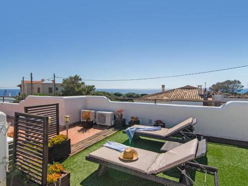 a patio with chairs and a table on a roof at Casa Lloc Tranquil in Cala Figuera