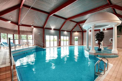 a large indoor pool with a large swimming pool at Glynhill Hotel & Spa near Glasgow Airport in Paisley