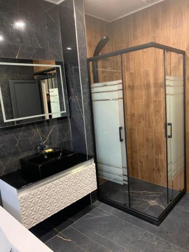a bathroom with a shower and a sink and a mirror at Апартамент Пламен in Vratsa