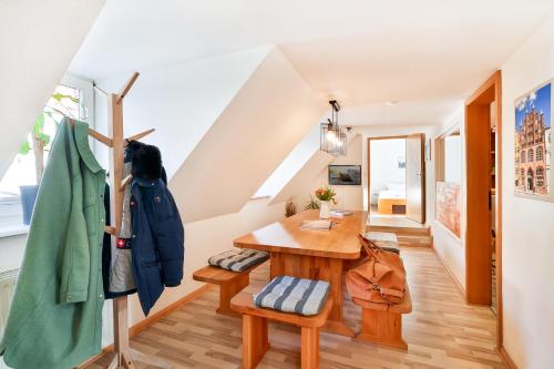 a room with a wooden table and a staircase at Ferienapartments Stralsund in Stralsund