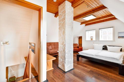 een slaapkamer en een woonkamer met een bed en een stenen pilaar bij Ferienappartements Stralsund in Stralsund