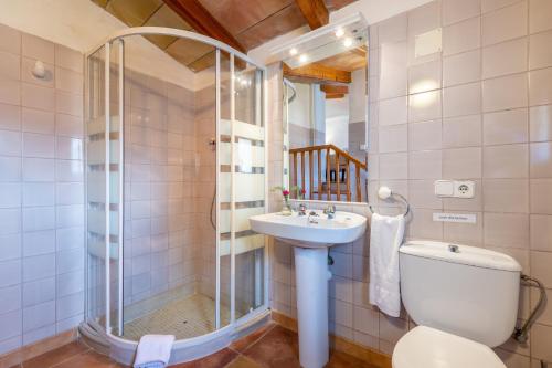 een badkamer met een douche, een toilet en een wastafel bij Can Jaumins in Sóller