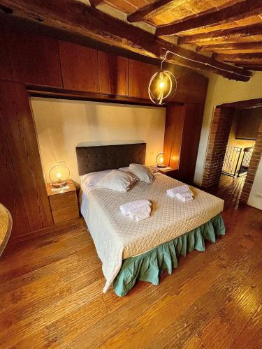 a bedroom with a large bed with two towels on it at Pergaccio Deluxe House in Cortona