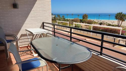 balcón con mesa y sillas y la playa en Playa Paraiso 21A, en Villajoyosa