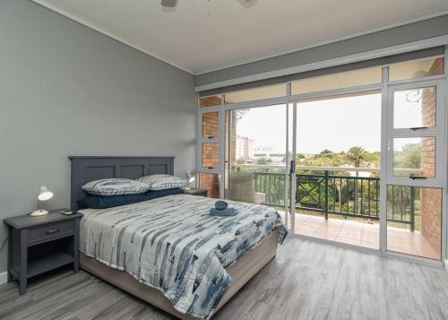 a bedroom with a bed and a balcony at 256 @ Brookes's in Summerstrand