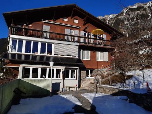 a large house with a balcony on top of it at Apartment Chalet Im sunnigen Usblick in Wengen