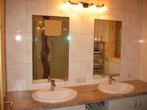 a bathroom with two sinks and two mirrors at Tomperkasa in Apriach