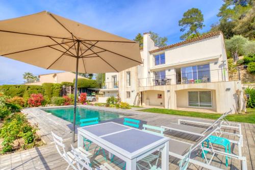 un patio avec un parasol et des chaises et une piscine dans l'établissement FRGK 