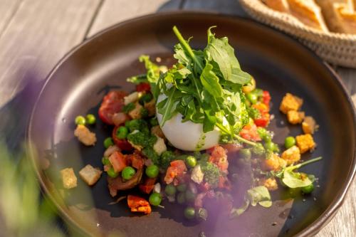 a plate of food with peas and vegetables on a table at Spa & GolfResort Weimarer Land in Blankenhain