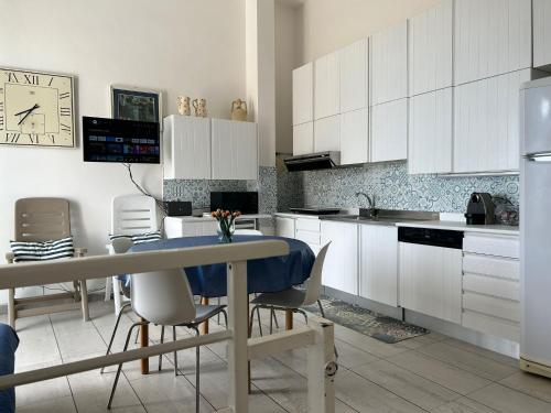 a kitchen with white cabinets and a table and chairs at A 100metri dal mare difronte alla torre saracena. in Campomarino