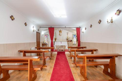 an empty church with wooden benches and a red carpet at Hotel Padre Pio by Umbral in Fátima