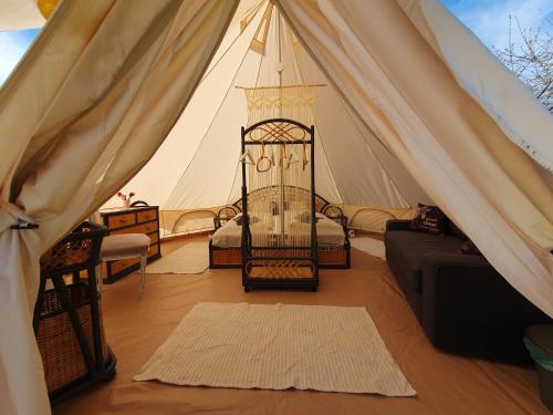 Zimmer mit einem Zelt mit einem Bett und einem Sofa in der Unterkunft Farm Glamping Ráckeve in Ráckeve