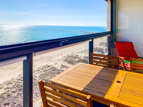 a table and chairs on a balcony overlooking the beach at ESPACIO 15 - Primera Línea de Playa in Cullera