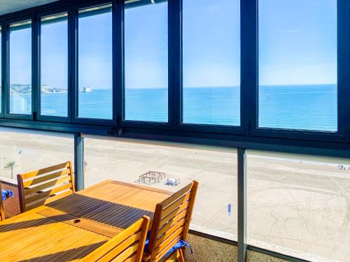a dining room with a table and views of the ocean at ESPACIO 15 - Primera Línea de Playa in Cullera