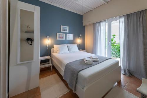 a bedroom with a bed and a large window at cosy house near the airport and the beach in Porto Rafti