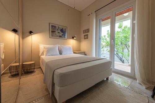 1 dormitorio con cama grande y ventana grande en cosy house near the airport and the beach en Porto Rafti