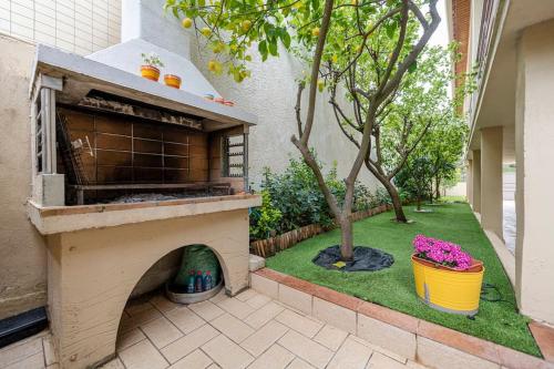 a patio with a pizza oven in a yard at cosy house near the airport and the beach in Porto Rafti