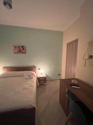 a bedroom with a bed and a dresser and a table at Casa Michele in Ercolano