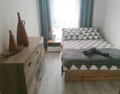 a bedroom with a bed and a dresser and a window at Apartament Pruszcz Gdański 1 in Pruszcz Gdański