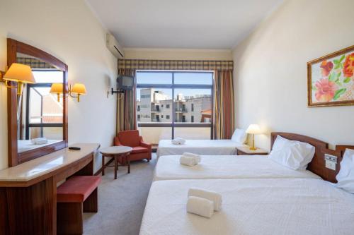 um quarto de hotel com duas camas e uma janela em Villa Fatima Hotel by Umbral em Fátima