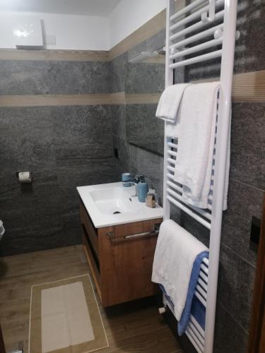 a bathroom with a sink and a mirror and towels at Appartamenti Lucianaz in Rhêmes-Notre-Dame