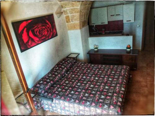 1 dormitorio con 1 cama con una rosa roja en la pared en La Piazzetta, en Nardò