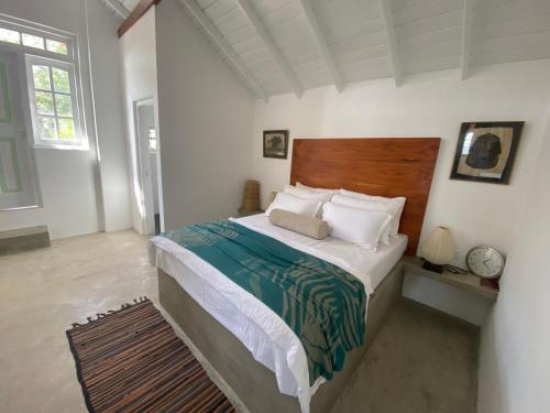 a bedroom with a large bed with a wooden headboard at Misty Hills Villa - Kandy in Kandy