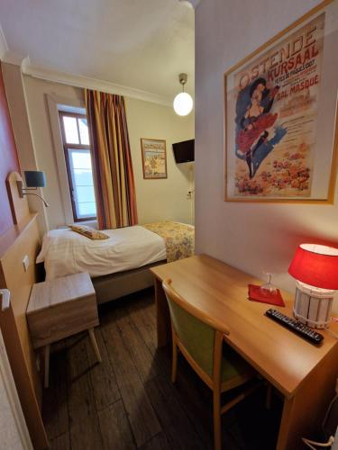 een hotelkamer met een bureau en een bed en een bureau sidx sidx sidx sidx bij Hotel Montana in De Panne