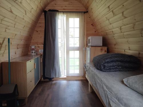 a bedroom with a bed and a window in a cabin at camping des ribieres in Confolens