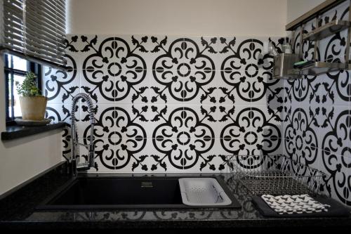 a kitchen with a black and white patterned wall at Zebra Cottage - House - Backup Power - Fast WIFI in Pretoria
