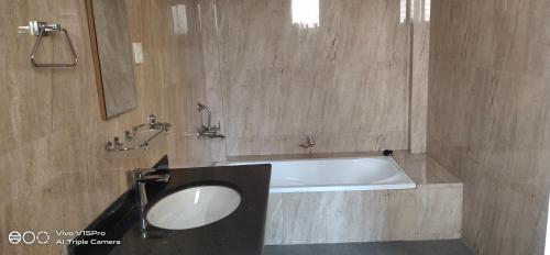a bathroom with a sink and a bath tub at Hotel hornbill in Sauraha