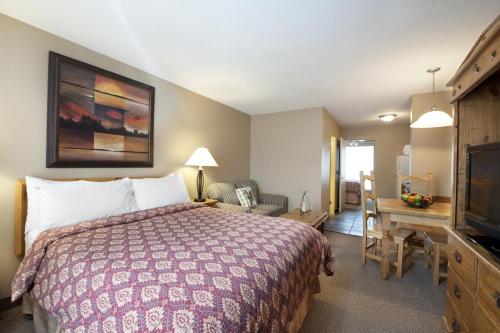 Habitación de hotel con cama y escritorio en Tonquin Inn en Jasper