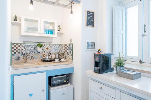 a kitchen with white cabinets and a counter with a microwave at Vico di Ostuni Apartments by Rentbeat in Ostuni