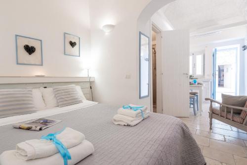 a bedroom with a bed with towels on it at Vico di Ostuni Apartments by Rentbeat in Ostuni