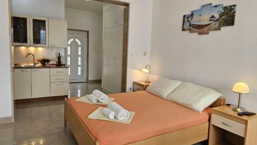 a bedroom with a bed with towels on it at Apartmani Barnjak in Trogir