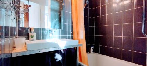La salle de bains est pourvue d'un lavabo, d'un miroir et d'une baignoire. dans l'établissement Villa Jardin fleuri, à Avignon