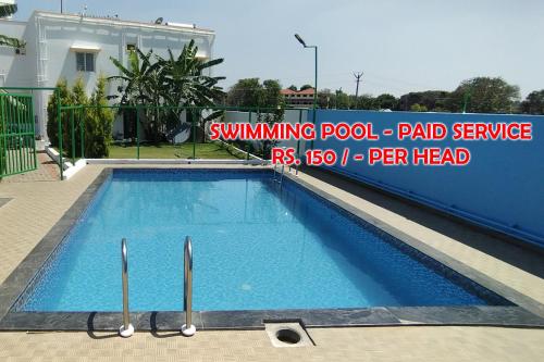 a swimming pool service sign in front of a house at Green Apple Resorts in Yelagiri