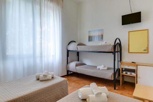 a room with three bunk beds and a television at Hotel Villa Merope in Rimini