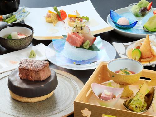 a table topped with plates of food and bowls at Hotel Tsubakino in Yamanouchi