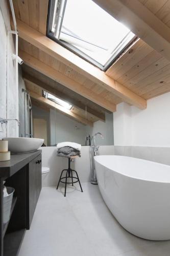 a bathroom with a large tub and a sink at Sibinicum luxury rooms in Šibenik