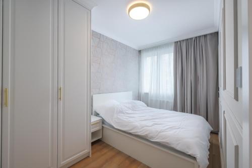 a small bedroom with a bed and a mirror at GLAMOUR GOLDEN LEAF in Gdańsk