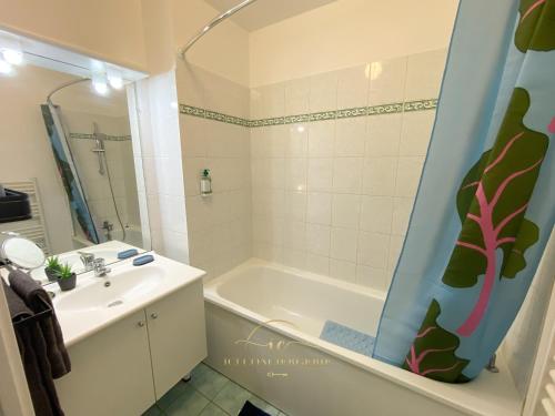 a bathroom with a tub and a sink and a bath tub at Le Cocon Melunais in Melun
