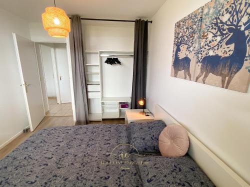 默倫的住宿－Le Cocon Melunais，卧室配有一张床,墙上挂有绘画作品