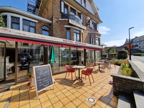 a hotel with tables and chairs in front of a building at Hotel Montana in De Panne