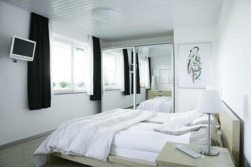 ein weißes Schlafzimmer mit einem Bett und einem Spiegel in der Unterkunft Apartment Schlossberg in Tübingen